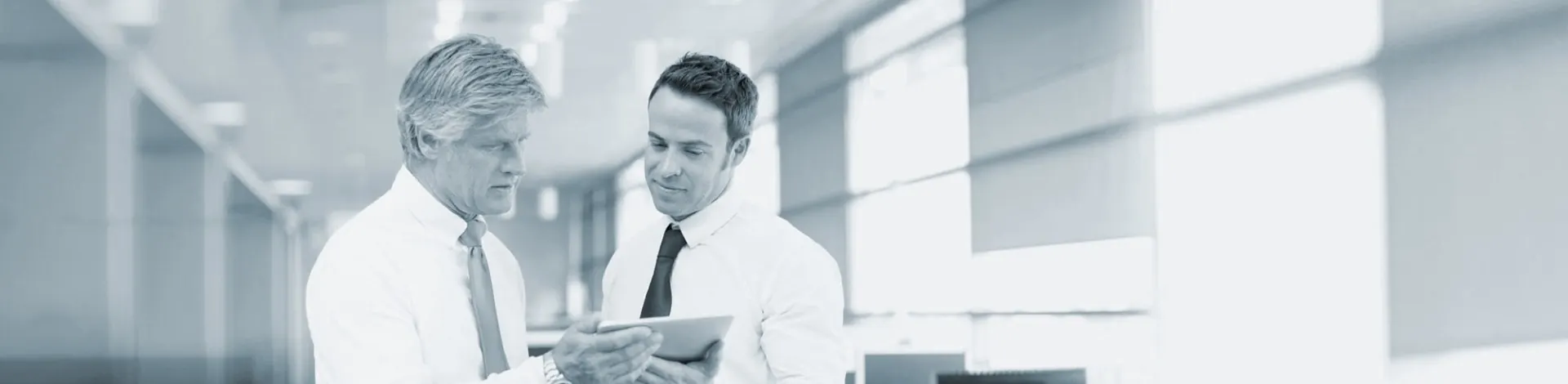 Dois executivos analisando dados num tablet
